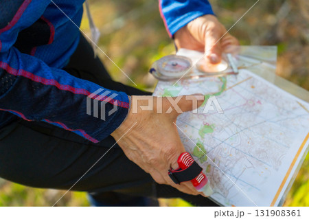 Orienteering athlete running through a summer forest with a map and compass. Orienteering athlete running through a summer forest with a map and compass. 131908361