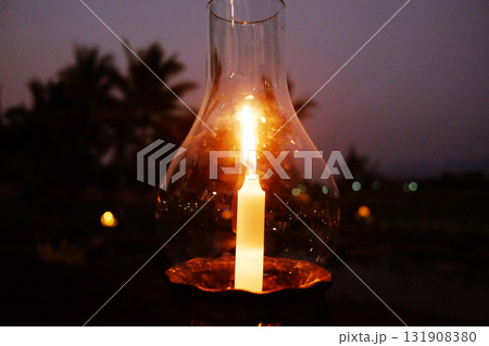 Close up beautiful candle light in glass bottle in dark and dusk evening and night scene Close up beautiful candle light in glass bottle in dark and dusk evening and night scene 131908380