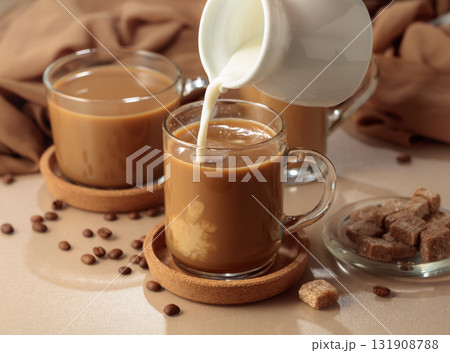 Pouring cream in black coffee. Pouring cream in black coffee. 131908788