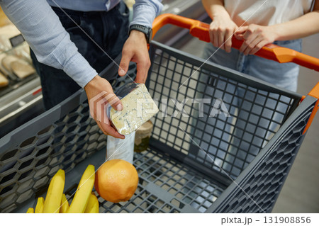 A man and a woman are shopping together in a grocery store A man and a woman are shopping together in a grocery store 131908856