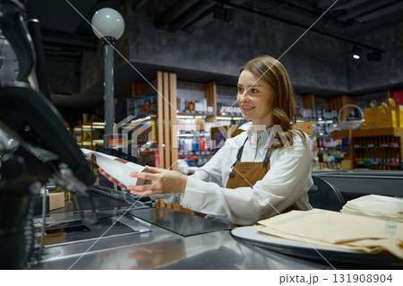 A woman cashier at a store counter is scanning an item A woman cashier at a store counter is scanning an item 131908904