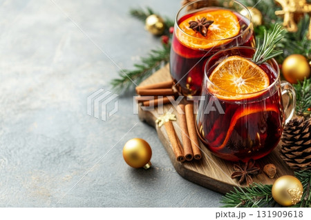 Hot red mulled wine with christmas spices, orange slice, anise and cinnamon sticks. Two glasses of mulled wine on white table with red checkered napkin with spices and fruits. Traditional Autumn drink Hot red mulled wine with christmas spices, orange slice, anise and cinnamon sticks. Two glasses of mulled wine on white table with red checkered napkin with spices and fruits. Traditional Autumn drink 131909618