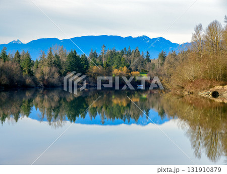 Autumn landscape scene with river, mountains and boat in a quiet factory Autumn landscape scene with river, mountains and boat in a quiet factory 131910879