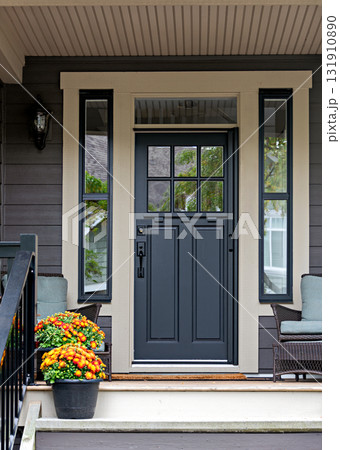Porch and entrance of a nice residential house with two flower pots 131910890
