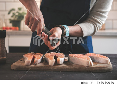 Woman Salting Raw Red Salmon For Cooking In The Kitchen Woman Salting Raw Red Salmon For Cooking In The Kitchen 131910919