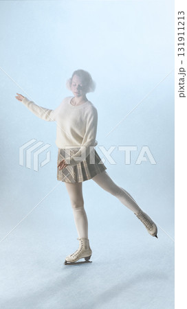 Young woman figure skater in white outfit gliding softly on ice with peaceful expression 131911213