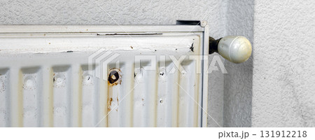Corrosion on the metal surface of a heating radiator in a room.aged radiator battery. Corrosion on the metal surface of a heating radiator in a room 131912218