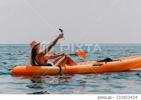 Kayaking Selfie Woman Ocean: A woman in a kayak takes a selfie while kayaking in the ocean. Kayaking Selfie Woman Ocean: A woman in a kayak takes a selfie while kayaking in the ocean. 131912414