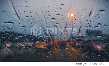 Atmospheric view of a rainy highway at dusk with water on the windshield and blurred taillights Atmospheric view of a rainy highway at dusk with water on the windshield and blurred taillights 131913425