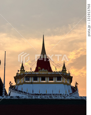 The Golden Mount Temple shines under a warm sunset sky in Bangkok reflecting peace faith and beauty of Thai culture. 131913768
