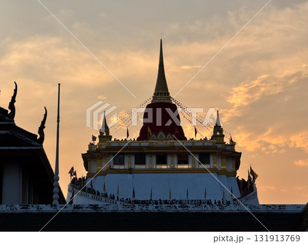 The Golden Mount Temple shines under a warm sunset sky in Bangkok reflecting peace faith and beauty of Thai culture. 131913769