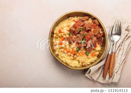 Moroccan couscous with tender meat and chickpea stew in rustic bow top view, Maghreb cuisine, space for text 131914313