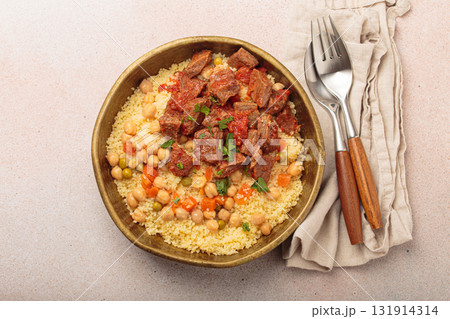 Moroccan couscous with tender meat and chickpea stew in rustic bow top view, Maghreb cuisine Moroccan couscous with tender meat and chickpea stew in rustic bow top view, Maghreb cuisine 131914314