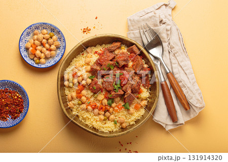 Moroccan couscous with tender meat and chickpea stew in rustic bow top view, Maghreb cuisine Moroccan couscous with tender meat and chickpea stew in rustic bow top view, Maghreb cuisine 131914320