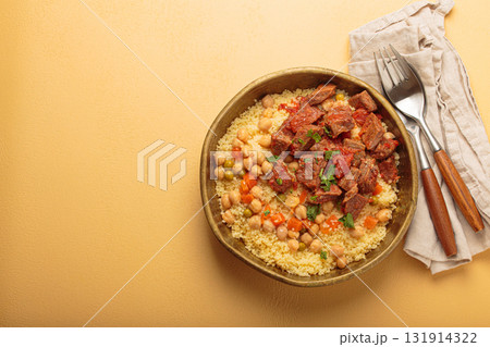 Moroccan couscous with tender meat and chickpea stew in rustic bow top view, Maghreb cuisine, space for text 131914322
