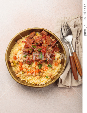 Moroccan couscous with tender meat and chickpea stew in rustic bow top view, Maghreb cuisine Moroccan couscous with tender meat and chickpea stew in rustic bow top view, Maghreb cuisine 131914337