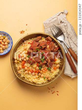 Moroccan couscous with tender meat and chickpea stew in rustic bow top view, Maghreb cuisine Moroccan couscous with tender meat and chickpea stew in rustic bow top view, Maghreb cuisine 131914347
