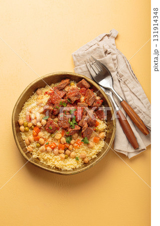 Moroccan couscous with tender meat and chickpea stew in rustic bow top view, Maghreb cuisine Moroccan couscous with tender meat and chickpea stew in rustic bow top view, Maghreb cuisine 131914348