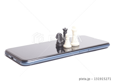 Chess pieces standing on the phone. Online chess game concept Chess pieces standing on the phone. Online chess game concept 131915271