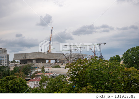 Construction, cranes, urban. Large scale building site with multiple industrial cranes against a cloudy city sky. 131915385