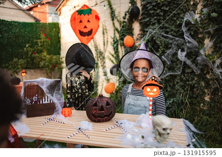 Children celebrating Halloween wearing costumes at a masquerade ball Children celebrating Halloween wearing costumes at a masquerade ball 131915595
