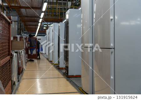 An assembly line or warehouse showing a row of modern refrigerators in a factory 131915624