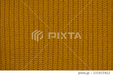 Close-up of warm mustard yellow knitted wool texture, cozy autumn winter fabric background 131915922