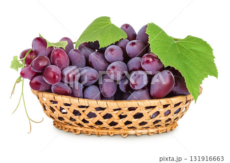 Red grape berry bunch in a wicker basket isolated on white background 131916663