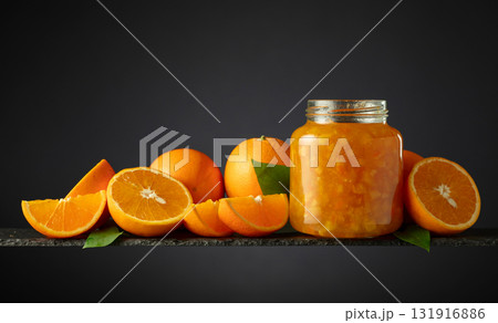 Orange jam in glass jar and fresh fruits. Orange jam in glass jar and fresh fruits. 131916886