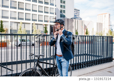 Urban commuter putting helmet on head before ride. 131917214