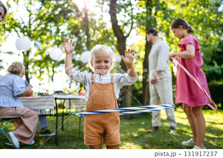Toddler boy playing with hula hoop, having fun during family picnic. 131917237