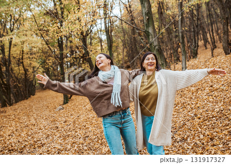 Mature daughter with older mom embracing in autumn park. Mother's day concept. Mature daughter with older mom embracing in autumn park. Mother's day concept. 131917327