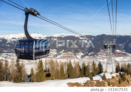 New modern spacious big cabin ski lift gondola against snowcapped forest tree and mountain peaks covered in snow landscape in luxury winter alpine resort. Winter leisure sports, recreation and travel New modern spacious big cabin ski lift gondola against snowcapped forest tree and mountain peaks covered in snow landscape in luxury winter alpine resort. Winter leisure sports, recreation and travel 131917535