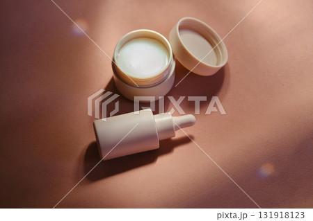 Face cream and serum on a soft beige background. 131918123