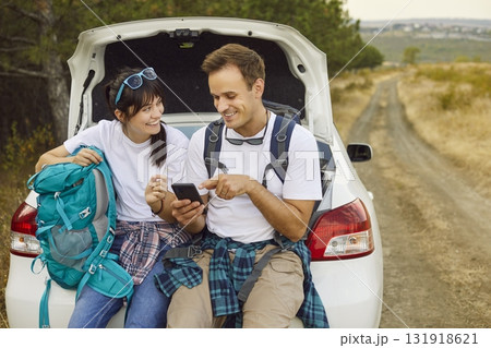 Lost travelers with backpacks using phone map by car on rural forest road 131918621