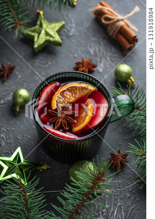 Holiday Mulled Wine with Orange and Apple in Green Mug Surrounded by Christmas Decor Holiday Mulled Wine with Orange and Apple in Green Mug Surrounded by Christmas Decor 131918984