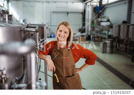 Woman brewer smiling in craft beer brewery Woman brewer smiling in craft beer brewery 131919207