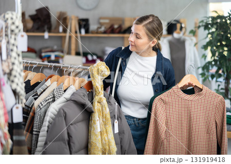 Woman browsing goods items and choose elect something autumn outwear 131919418