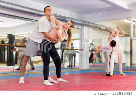 Self-defense course - a woman trains to do painful grip and painful blows to man Self-defense course - a woman trains to do painful grip and painful blows to man 131919454