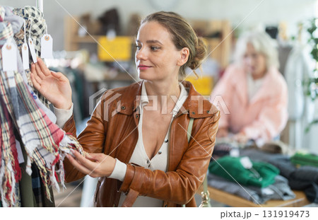 European woman customer examine and choose scarf in store 131919473