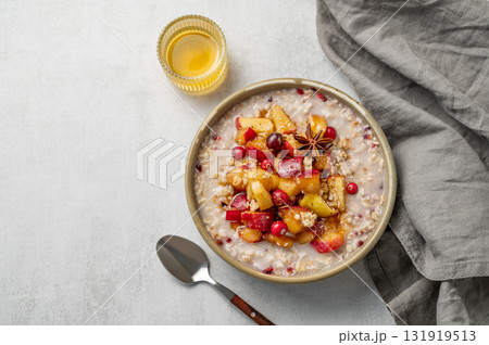 Overnight oatmeal with apples, cranberries, and cinnamon in a bowl on a light background 131919513