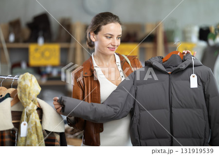 Young woman chooses sweater in clothing store 131919539