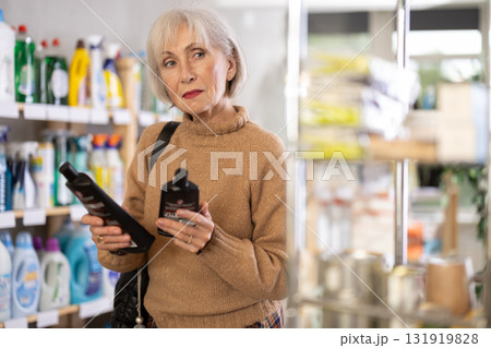 Mature woman chooses products for glass-ceramics 131919828