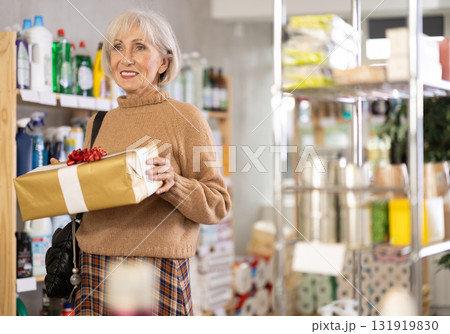 Elderly European woman with gift box in store Elderly European woman with gift box in store 131919830