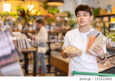 Store visitor, guy in sales area choosing pasta Store visitor, guy in sales area choosing pasta 131919861