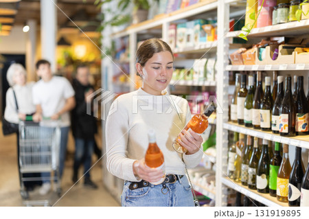 Woman choosing wine in a store 131919895