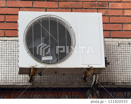 Outdoor air conditioner unit on a brick wall. Urban infrastructure, ventilation system and energy technology representing climate control and industrial design. 131920555