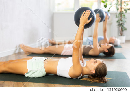 Sporty teen girl training with bender ball at gym Sporty teen girl training with bender ball at gym 131920600