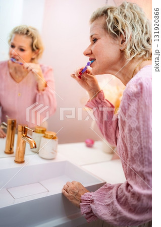 Woman brushing teeth in bathroom mirror reflection 131920866