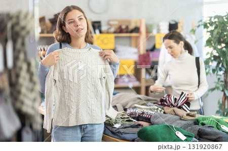 Young woman choosing sweater in clothing store Young woman choosing sweater in clothing store 131920867